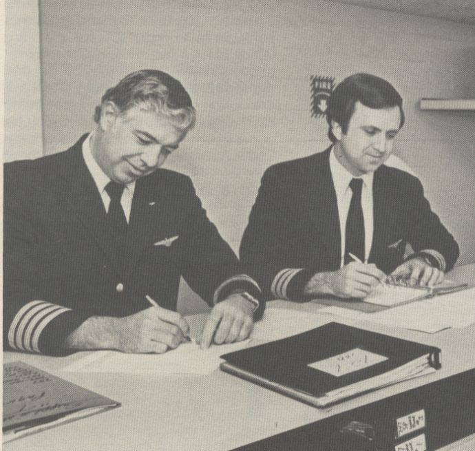 1981 Pan Am pilots prepare pre-flight paperwork.